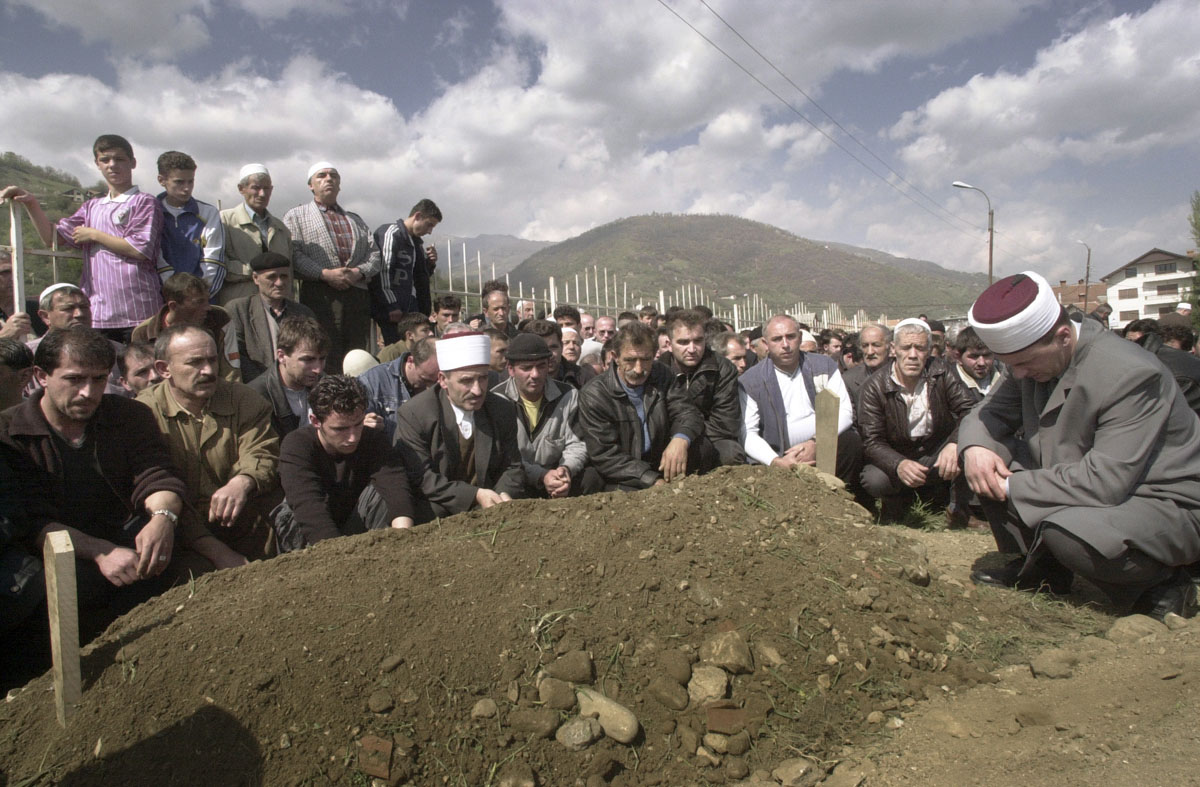 Ethnic Albanians pay their respect during the burial of a fallen KLA rebel.