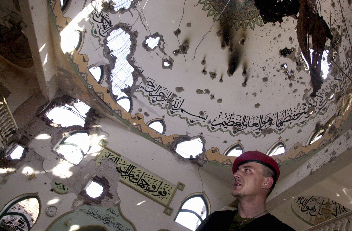 A KLA commander in the severely damaged mosque of Matecje.